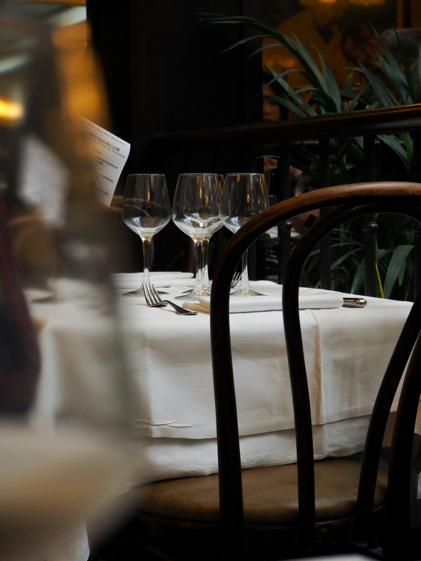 Restaurant table set with wine glasses and white linen